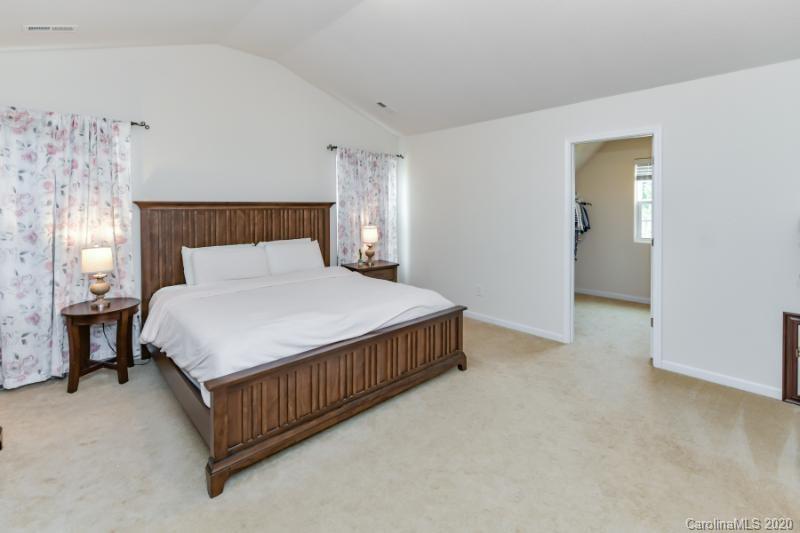 6565 Paw Village Road Charlotte, NC 28214 - Photo 10 of 26 a bed sitting in a bedroom next to a lamp