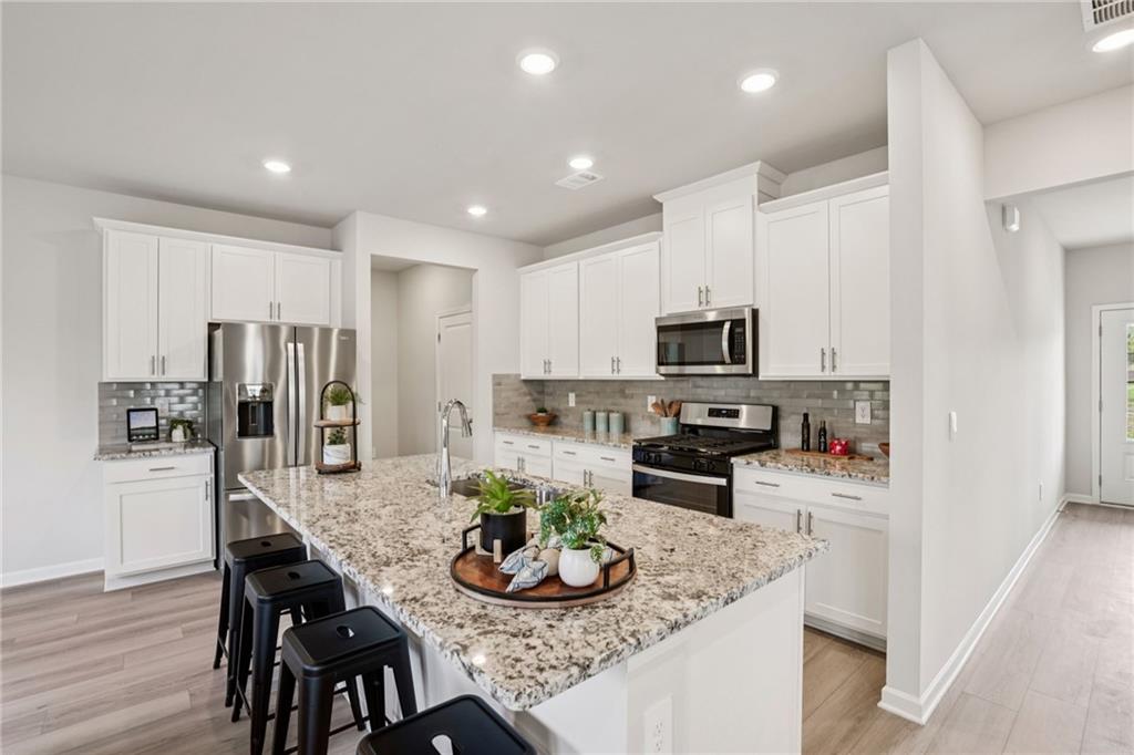202 Proust Circle Dallas, GA 30132 - Photo 16 of 47 a kitchen with stainless steel appliances granite countertop a stove refrigerator and microwave