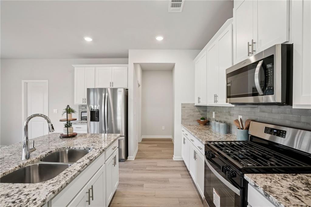 202 Proust Circle Dallas, GA 30132 - Photo 17 of 47 a kitchen with stainless steel appliances granite countertop a sink stove and refrigerator