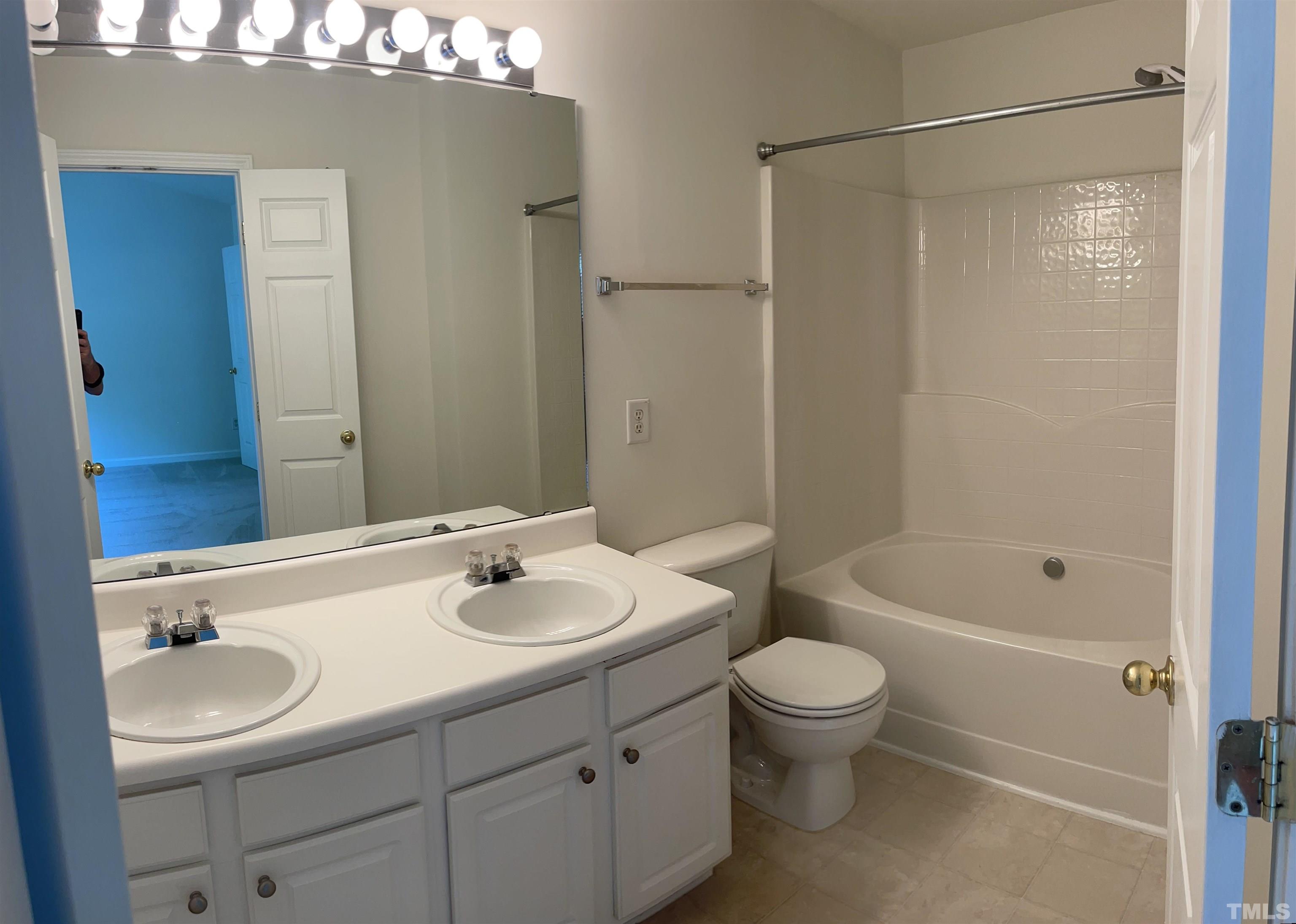 8521 Bright Loop Raleigh, NC 27613 - Photo 14 of 20 a bathroom with a sink a toilet and shower