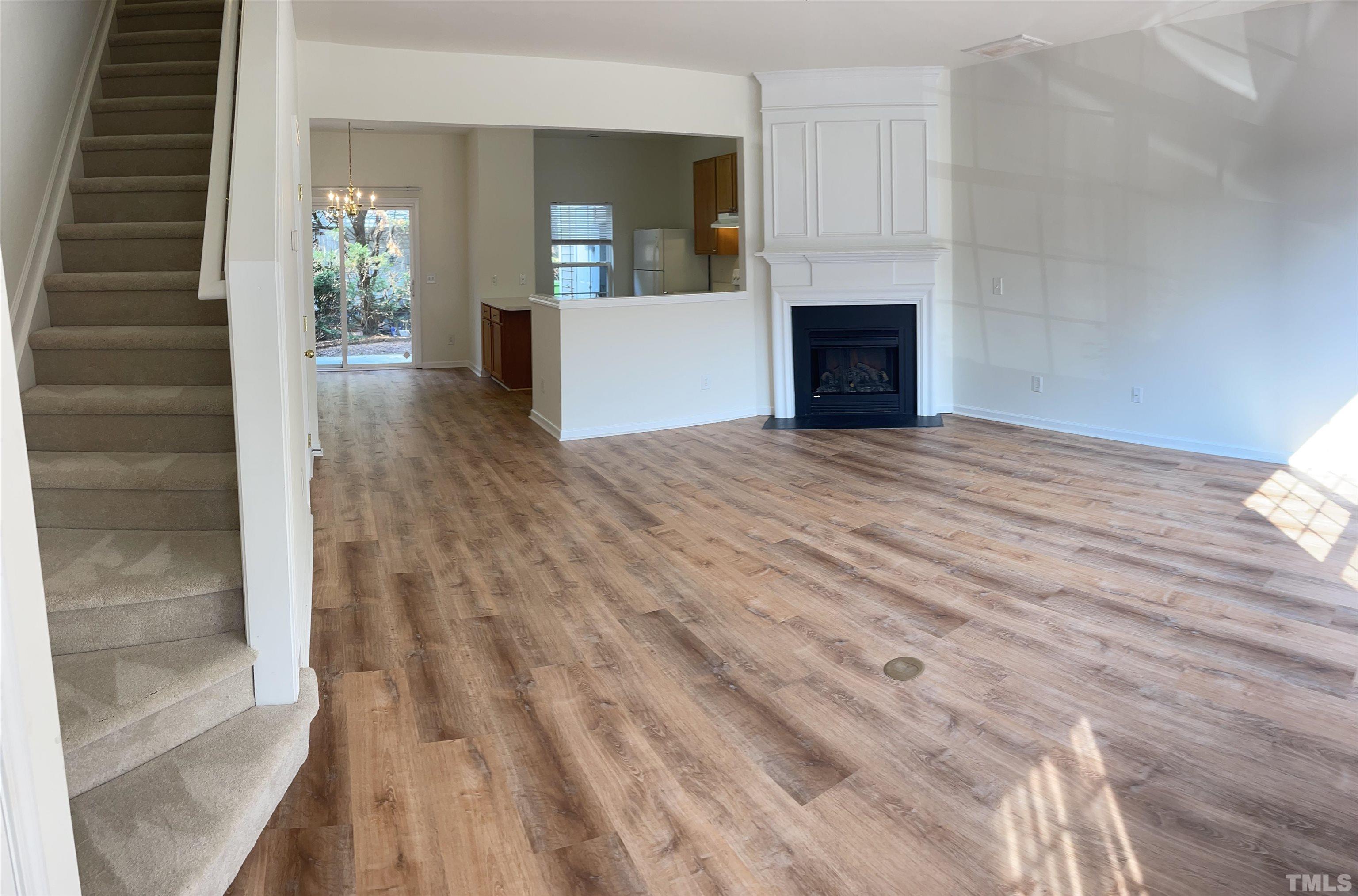 8521 Bright Loop Raleigh, NC 27613 - Photo 2 of 20 a view of a livingroom with wooden floor and stairs
