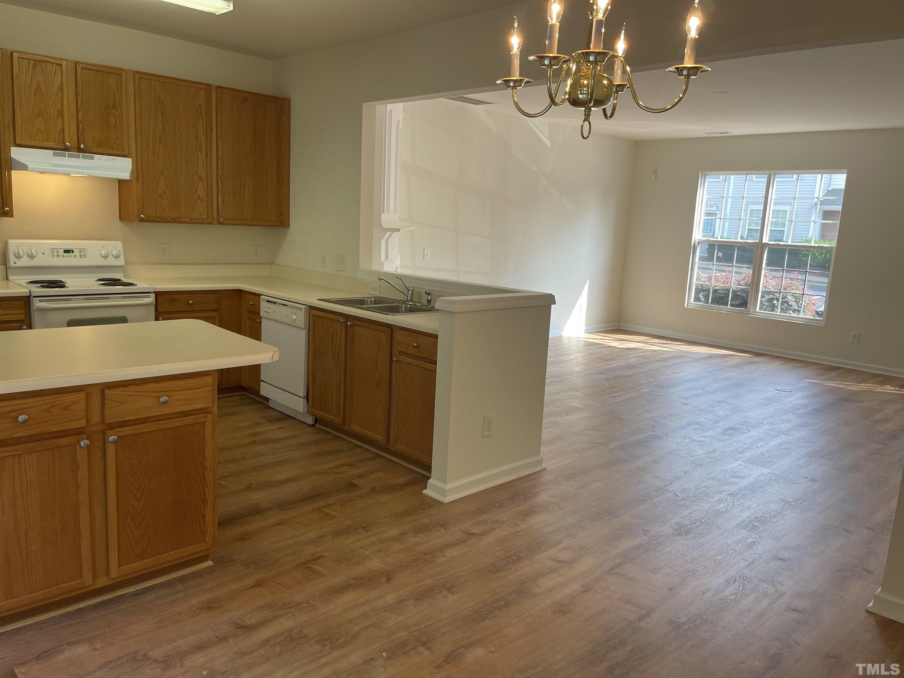 8521 Bright Loop Raleigh, NC 27613 - Photo 4 of 20 a kitchen with stainless steel appliances granite countertop a sink a stove and a wooden floors