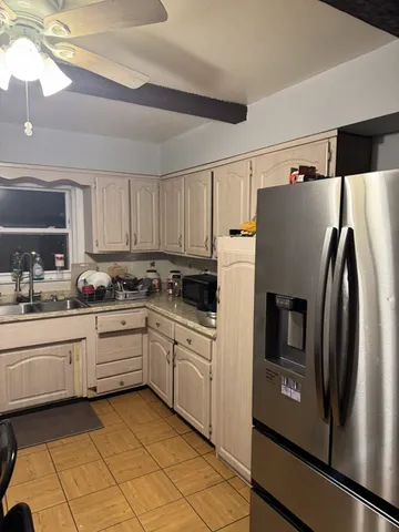 a kitchen with granite countertop a refrigerator and a stove top oven