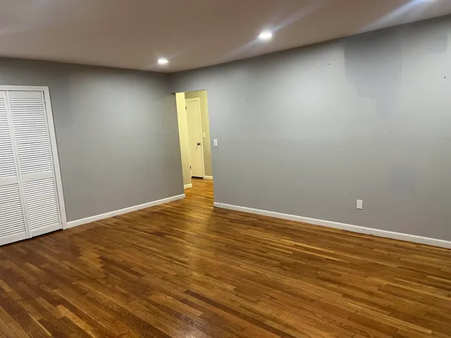 an empty room with wooden floor and entrance