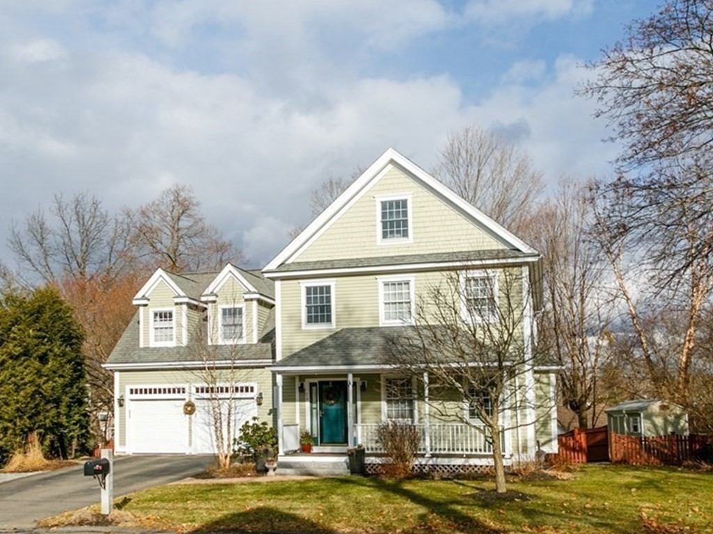 a front view of a house with a garden and trees