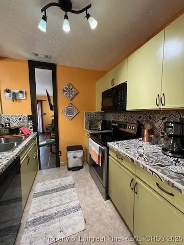 a kitchen with a stove a sink and a refrigerator