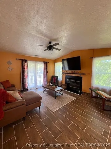 a living room with furniture a window and a flat screen tv