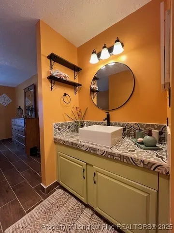 a bathroom with a granite countertop sink and mirror