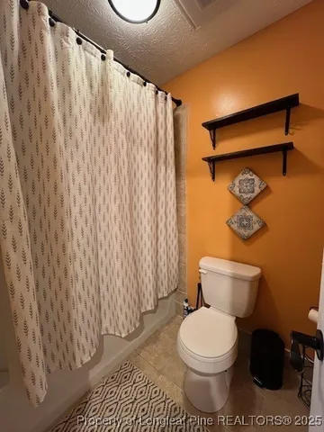 a white toilet sitting next to a shower curtain