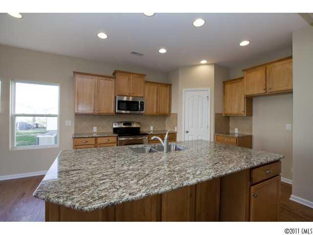 2183 Durand Road, Unit 84 Fort Mill, SC 29715 - Photo 6 of 16 a kitchen with kitchen island granite countertop a sink window and refrigerator