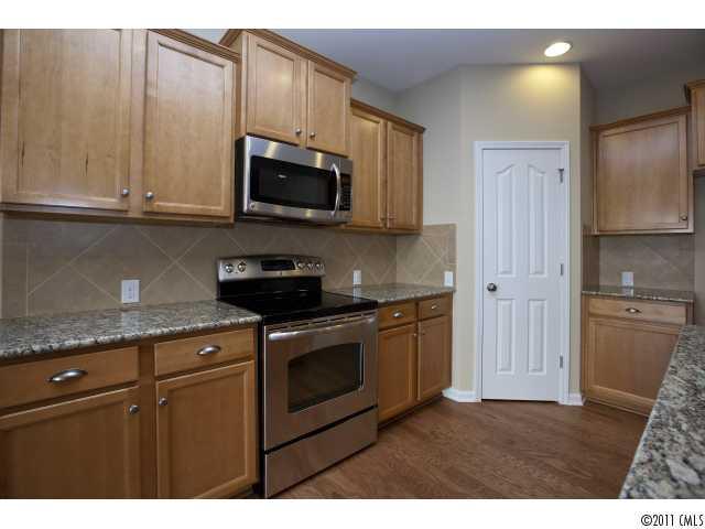 2183 Durand Road, Unit 84 Fort Mill, SC 29715 - Photo 7 of 16 a kitchen with stainless steel appliances granite countertop a stove a sink and a microwave