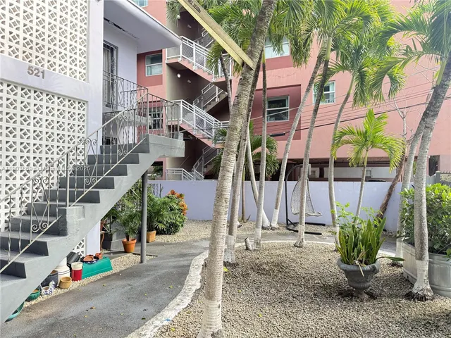 a white house that has a tree in front of it