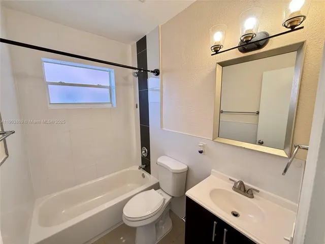 a bathroom with a sink a toilet a mirror and shower