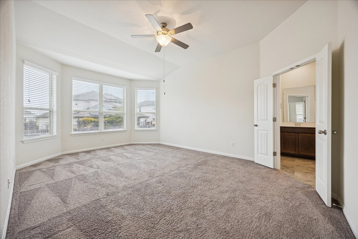 19201 Quebrada Drive Pflugerville, TX 78660 - Photo 12 of 22 an empty room with windows and ceiling fan