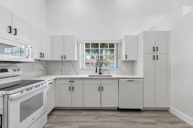 a kitchen with a sink cabinets and window