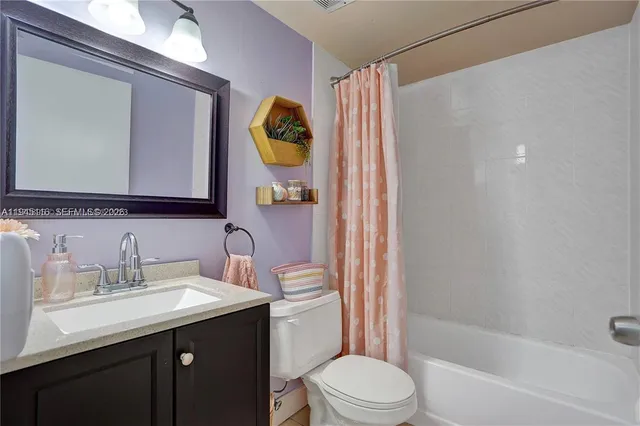 a bathroom with a sink vanity mirror and toilet