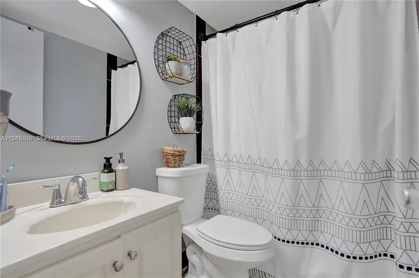 a bathroom with a sink mirror and toilet
