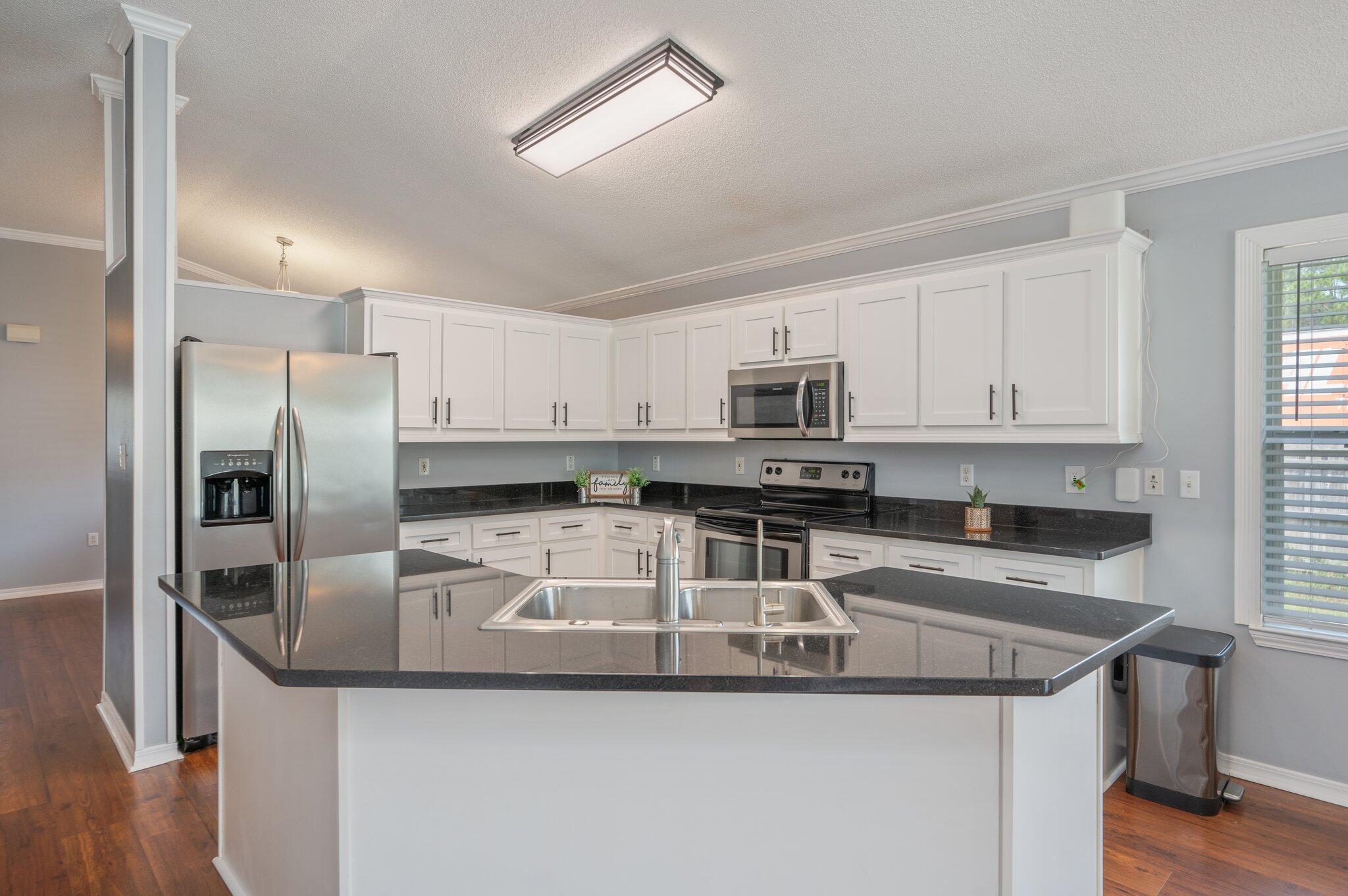 695 Randall Roberts Road Fort Walton Beach, FL 32547 - Photo 11 of 40 a kitchen with stainless steel appliances granite countertop a sink a stove and a refrigerator