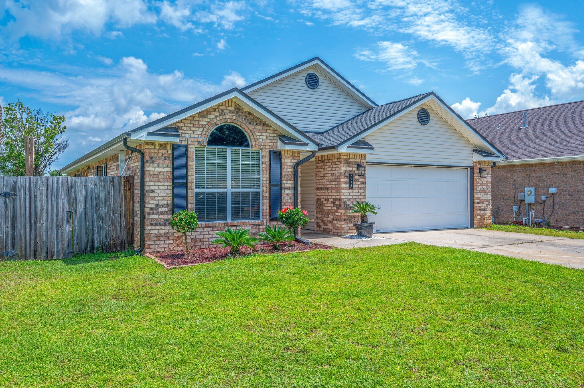 695 Randall Roberts Road Fort Walton Beach, FL 32547 - Photo 2 of 40 a front view of a house with a yard and garage