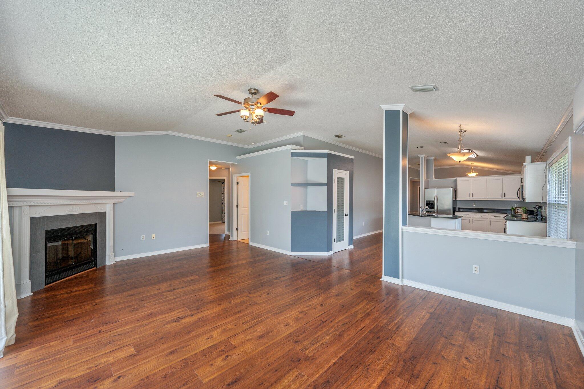 695 Randall Roberts Road Fort Walton Beach, FL 32547 - Photo 21 of 40 a view of an empty room and kitchen with wooden floor