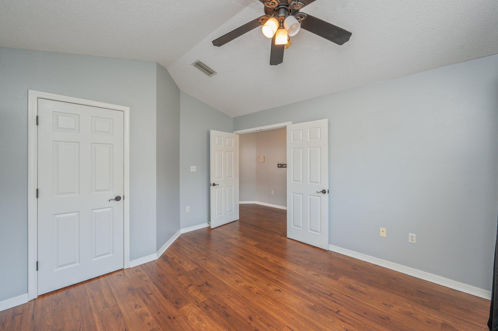 695 Randall Roberts Road Fort Walton Beach, FL 32547 - Photo 6 of 40 wooden floor in an empty room with a chandelier fan