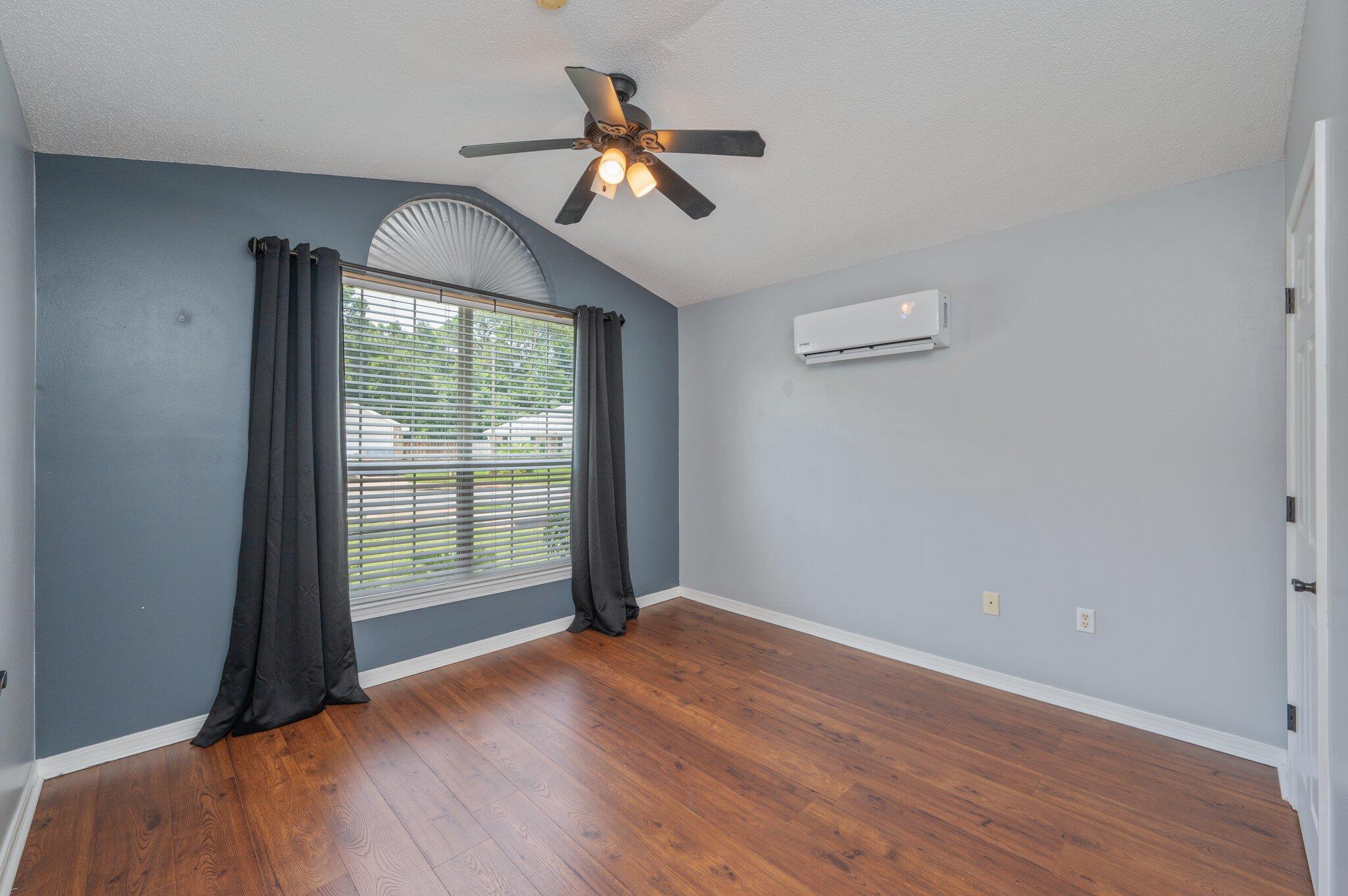695 Randall Roberts Road Fort Walton Beach, FL 32547 - Photo 7 of 40 an empty room with wooden floor fan and windows