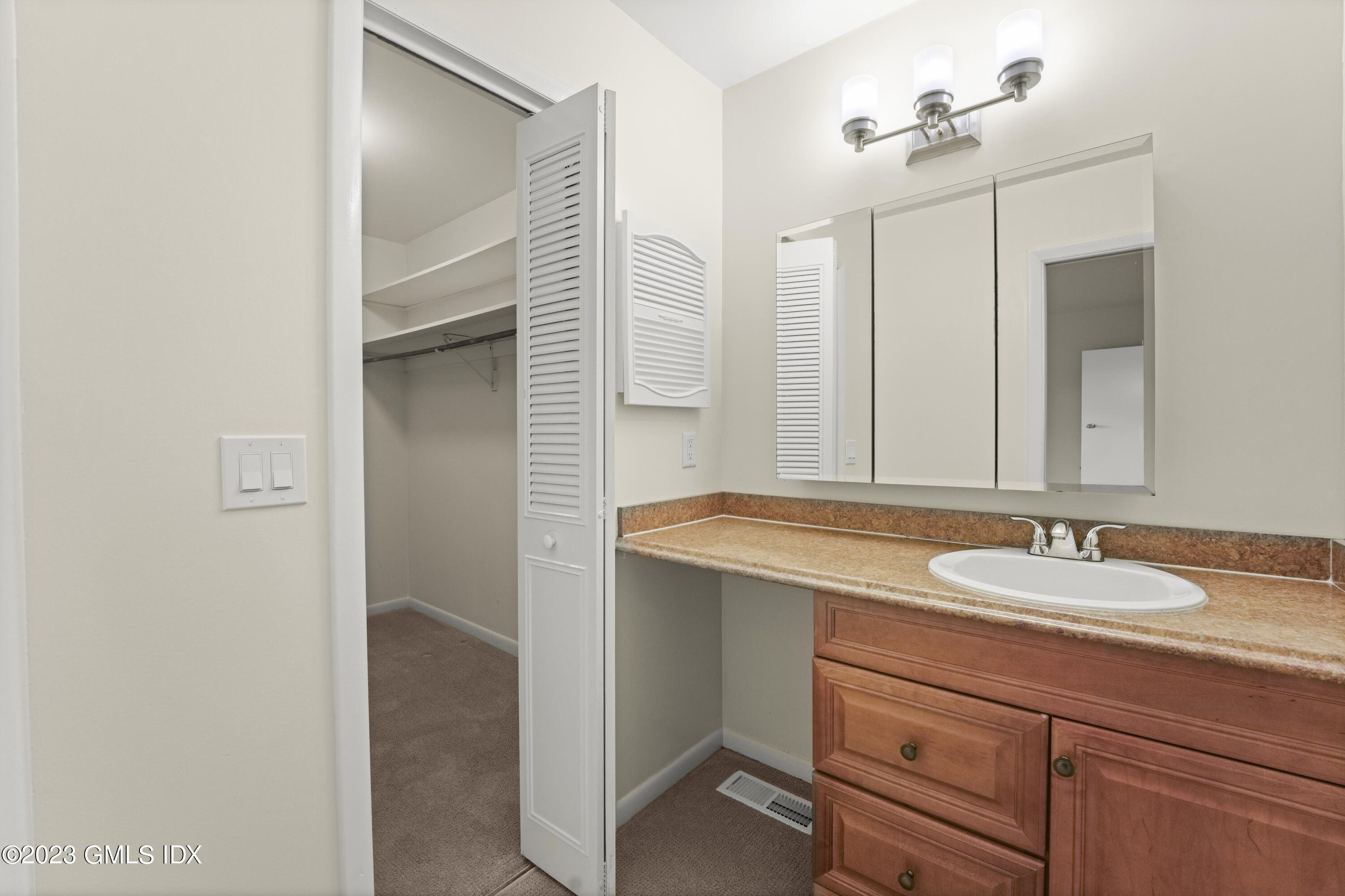 76 Silo Circle, Unit 76 Riverside, CT 06878 - Photo 20 of 40 a bathroom with a granite countertop sink and a mirror