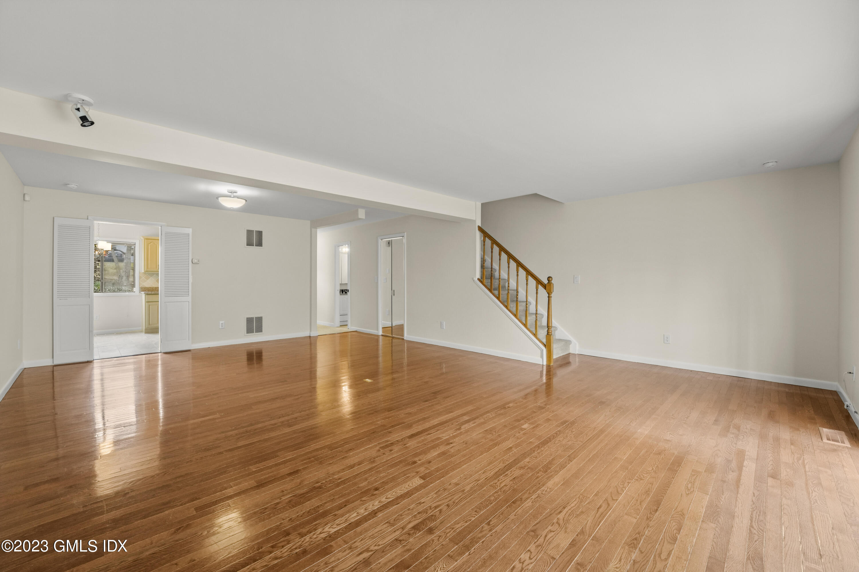 76 Silo Circle, Unit 76 Riverside, CT 06878 - Photo 5 of 40 a view of an empty room with wooden floor and a window