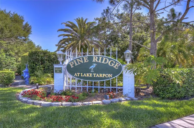 a front view of multi story residential apartment building with yard and sign board