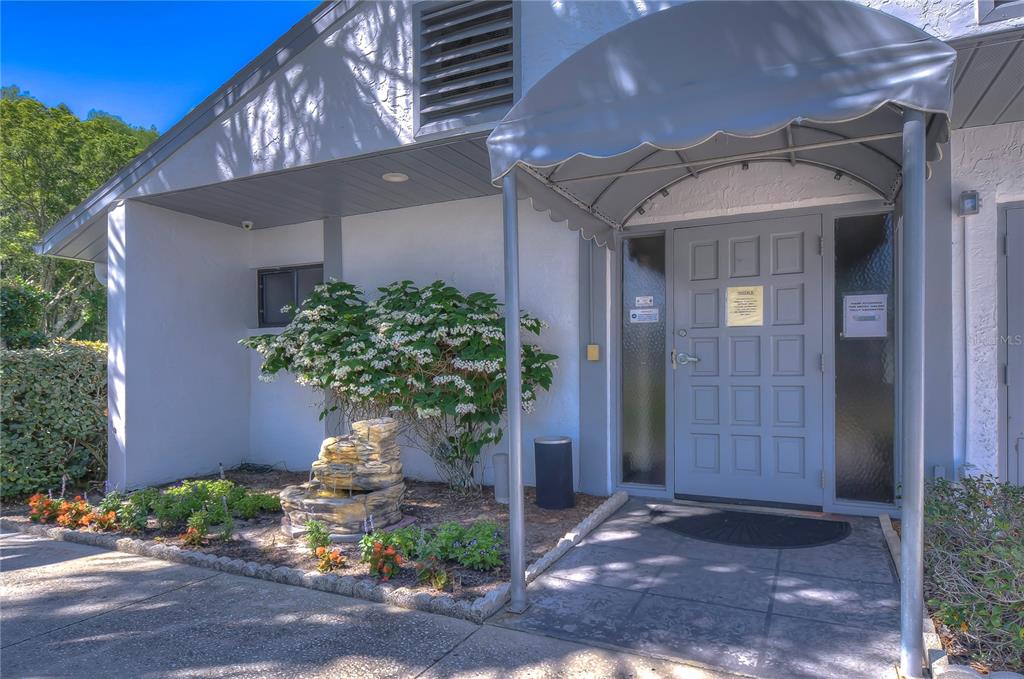 1389 Pine Ridge Circle East, Unit D8 Tarpon Springs, FL 34688 - Photo 28 of 30 a front view of a house with a yard
