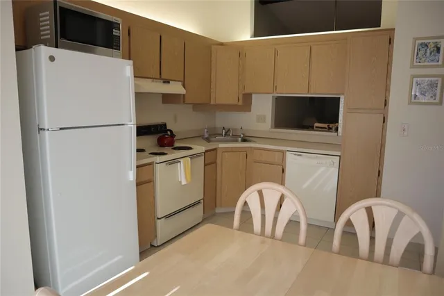 a kitchen with a refrigerator a microwave a sink and cabinets