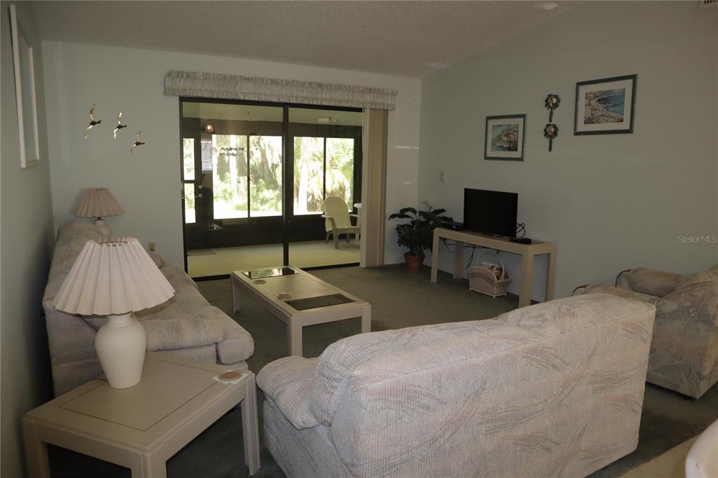 1389 Pine Ridge Circle East, Unit D8 Tarpon Springs, FL 34688 - Photo 8 of 30 a bedroom with a bed and a chair