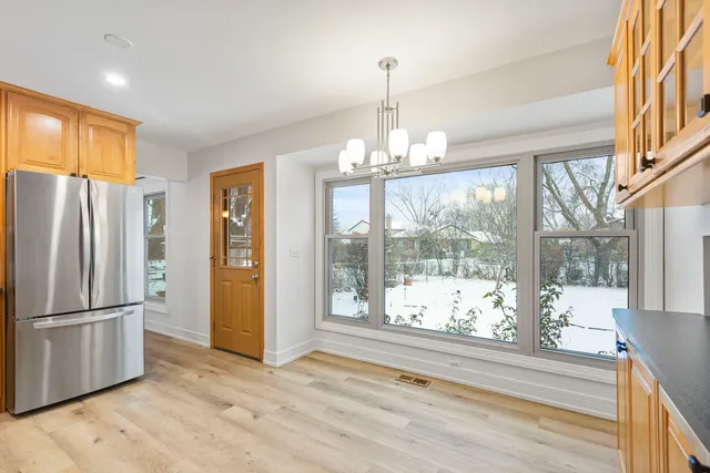 a view of a kitchen with granite countertop a refrigerator and wooden floor