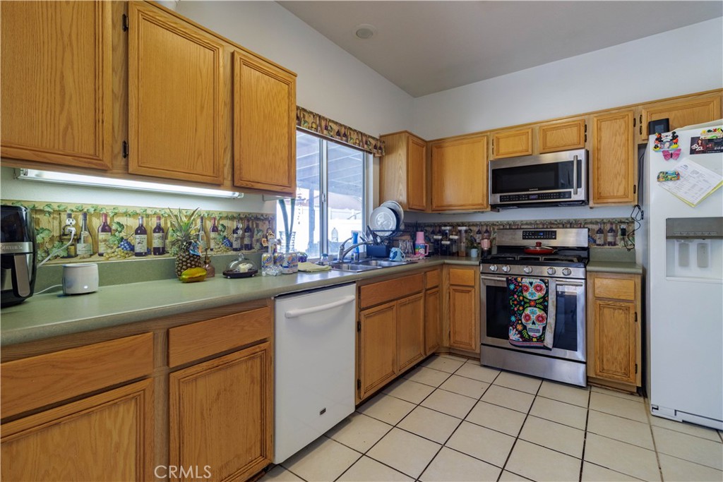1393 Rabbit Peak Way Hemet, CA 92545 - Photo 11 of 34 a kitchen with stainless steel appliances granite countertop a stove a sink and a microwave