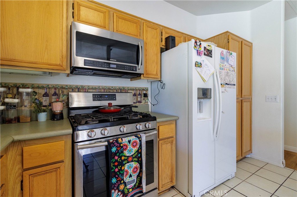 1393 Rabbit Peak Way Hemet, CA 92545 - Photo 12 of 34 a kitchen with stainless steel appliances granite countertop a stove and a refrigerator