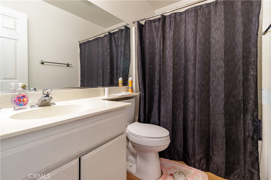1393 Rabbit Peak Way Hemet, CA 92545 - Photo 22 of 34 a bathroom with a sink a toilet a mirror and shower curtain