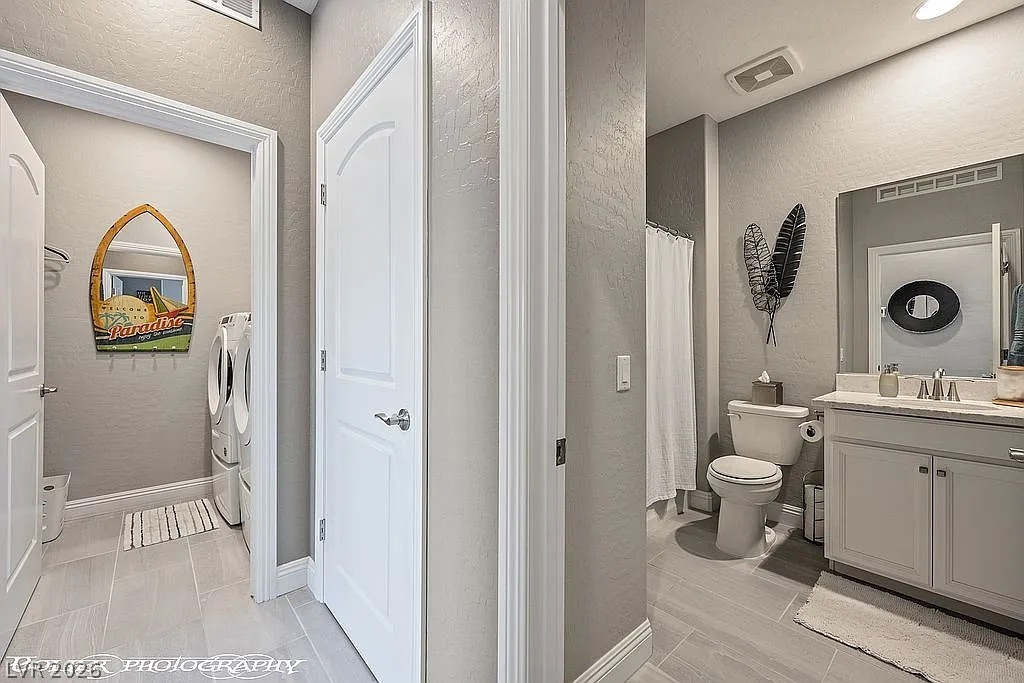 1304 Cottage Ridge Mesquite, NV 89034 - Photo 22 of 52 A well-appointed bathroom offers sleek vanity and tiled flooring, conveniently adjacent to a dedicated laundry area.