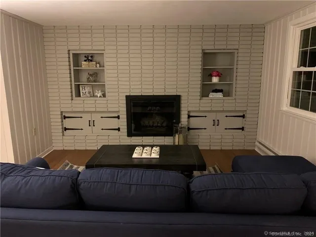 a living room with furniture a flat screen tv and a fireplace