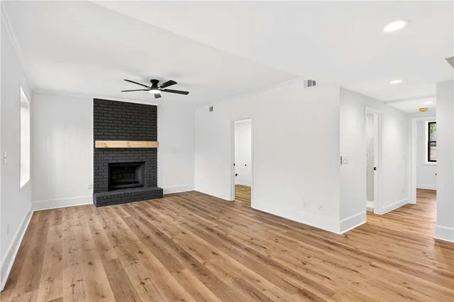 a view of empty room with wooden floor and fireplace