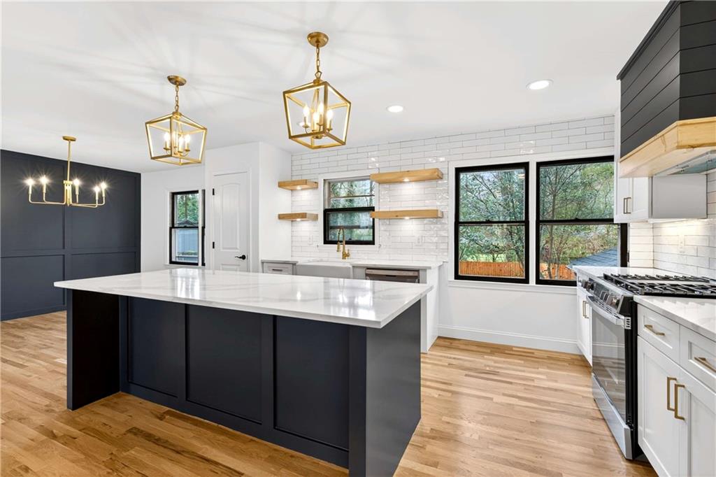 671 Willow Ridge Drive Northeast Marietta, GA 30068 - Photo 3 of 36 a kitchen with a stove a sink a window and chairs