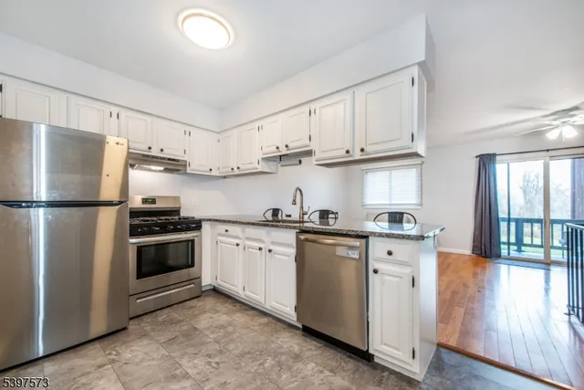 a kitchen with stainless steel appliances granite countertop a refrigerator sink and cabinets