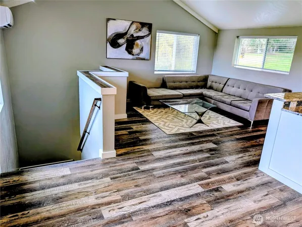 a kitchen with stainless steel appliances granite countertop a stove top oven a sink dishwasher a dining table and chairs with wooden floor