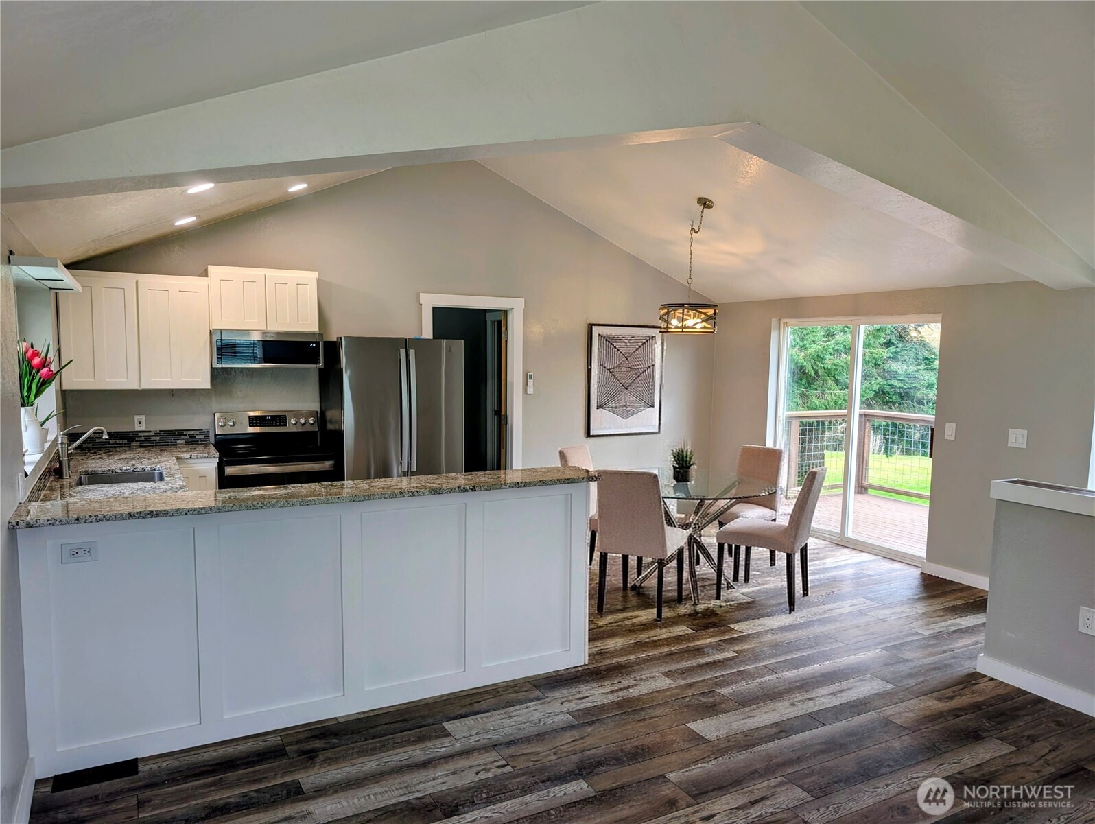 11108 Bliss Cochrane Road Northwest Gig Harbor, WA 98329 - Photo 13 of 39 a kitchen with stainless steel appliances granite countertop a stove top oven a sink dishwasher a dining table and chairs with wooden floor