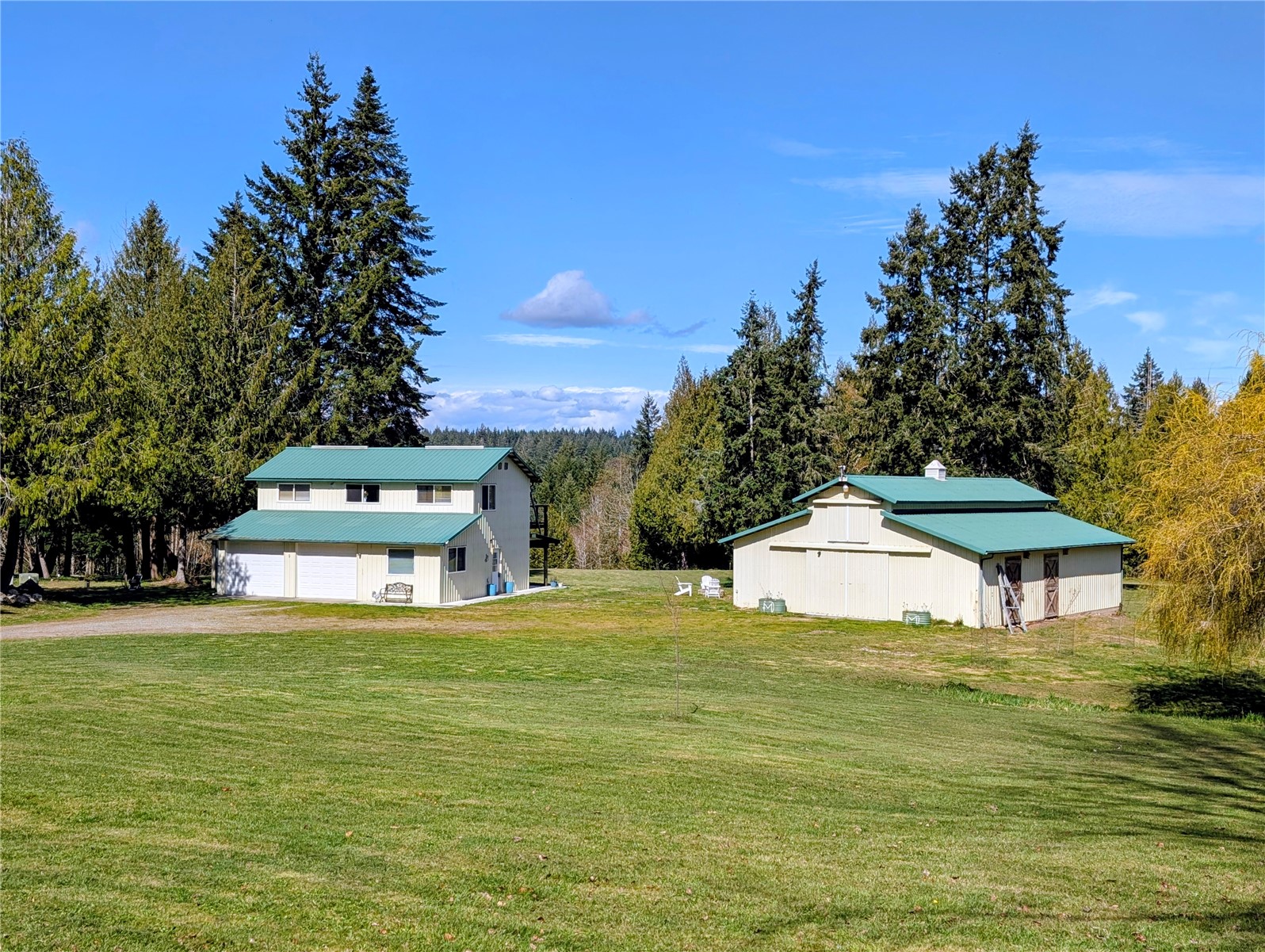 11108 Bliss Cochrane Road Northwest Gig Harbor, WA 98329 - Photo 3 of 39 a white house with a big yard and large trees