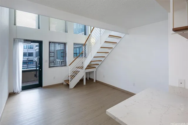 a view of an empty room with stairs and furniture