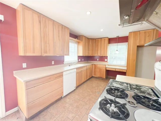 a kitchen with a stove a sink and a window