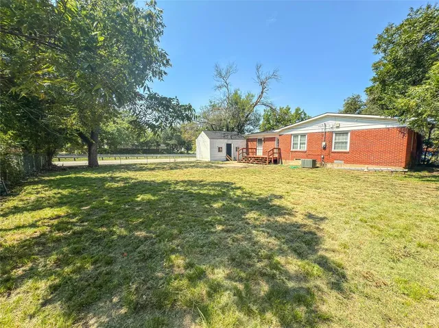 a view of a house with a big yard and large trees