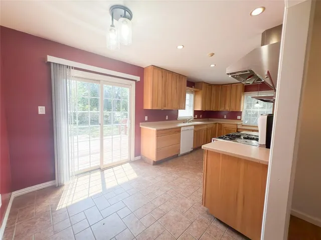 a kitchen with a refrigerator a sink and a stove top oven