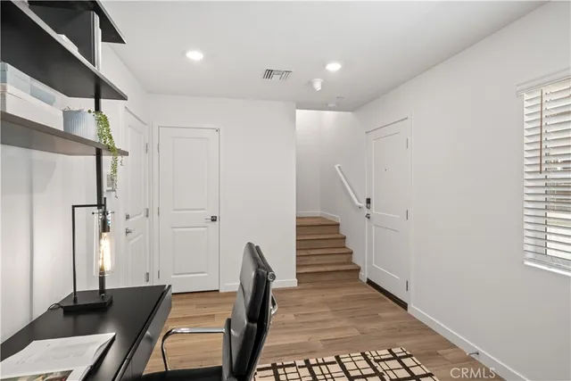 a view of a hallway with wooden floor and stairs