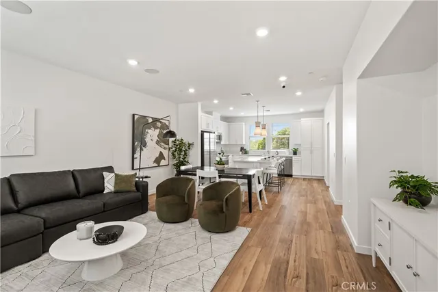 a living room with furniture a wooden floor and a chandelier